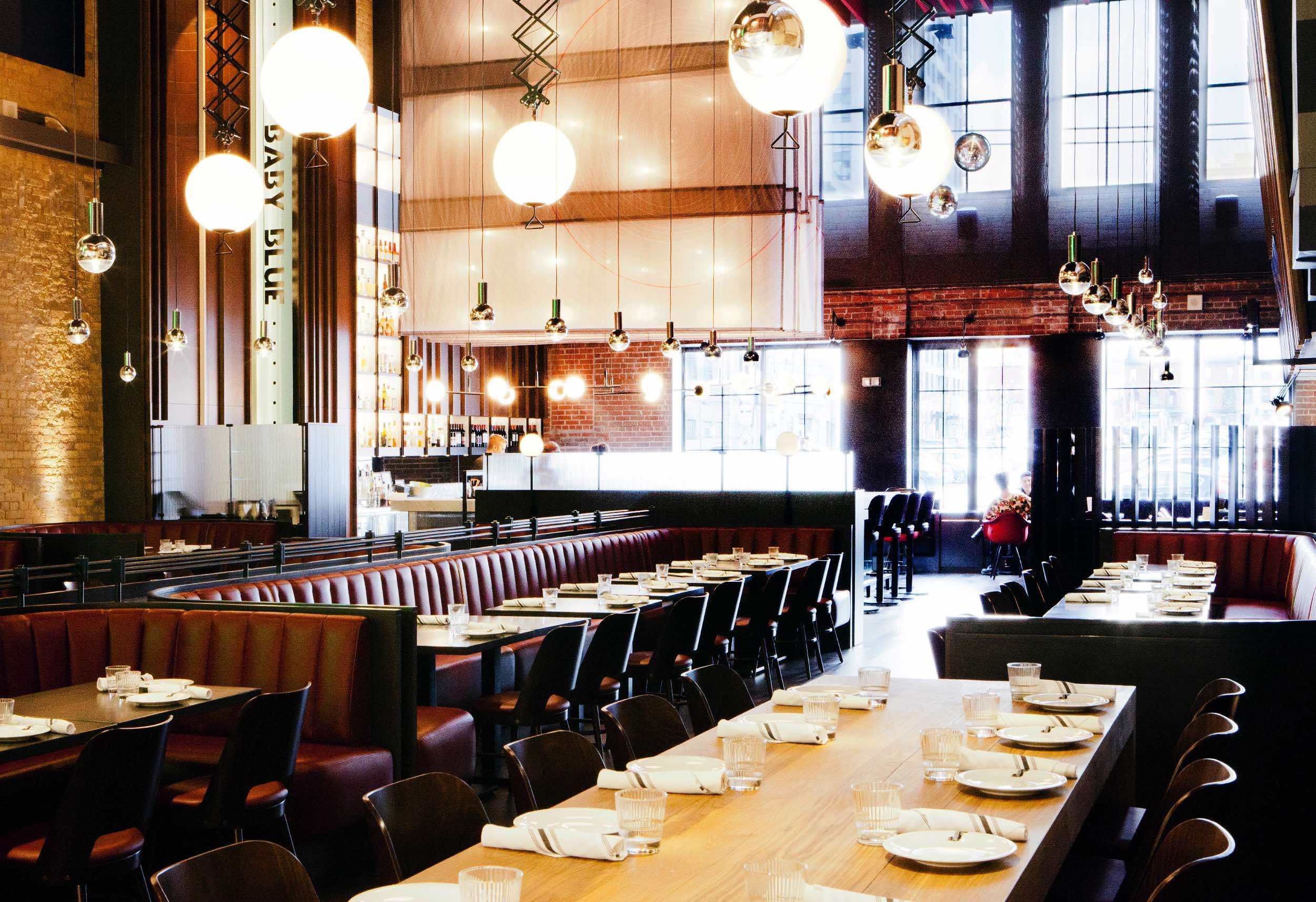 The Carbon Bar dining room with banquettes, art, and the open kitchen in view